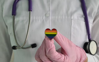 Woman doctor with lgbt heart flag in hand in clinic